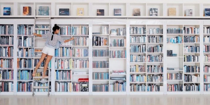 Empleada de una librería organizando los libros en las estanterías.