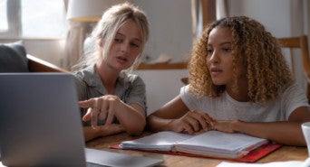 Two people working at a laptop