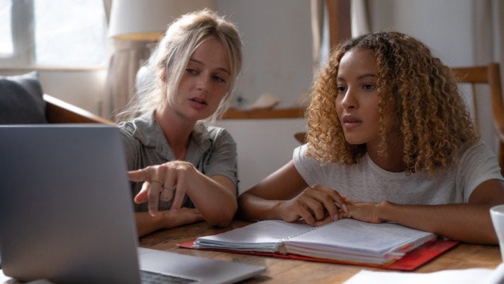 Two people working at a laptop