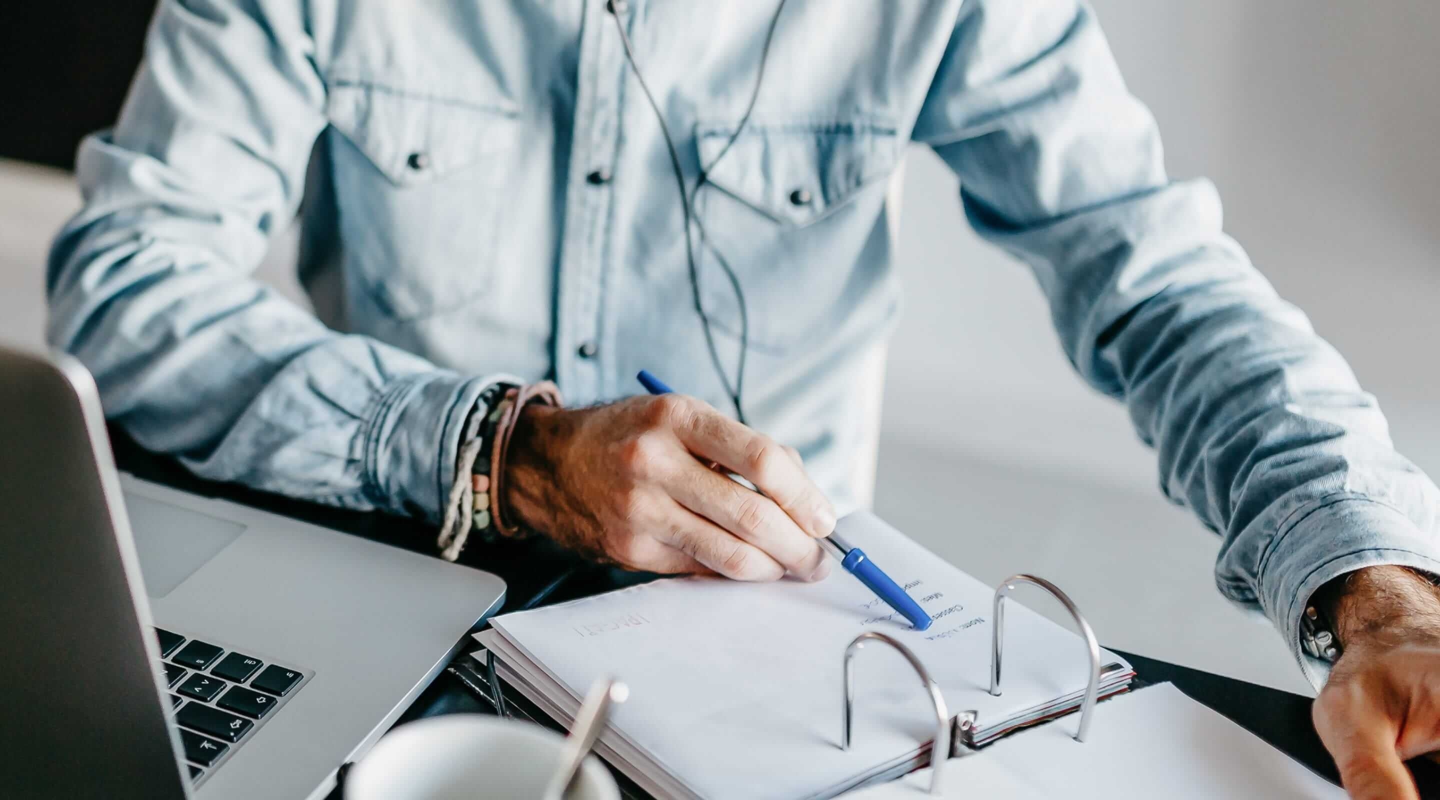 Man stelt op laptop juridische teksten op voor website