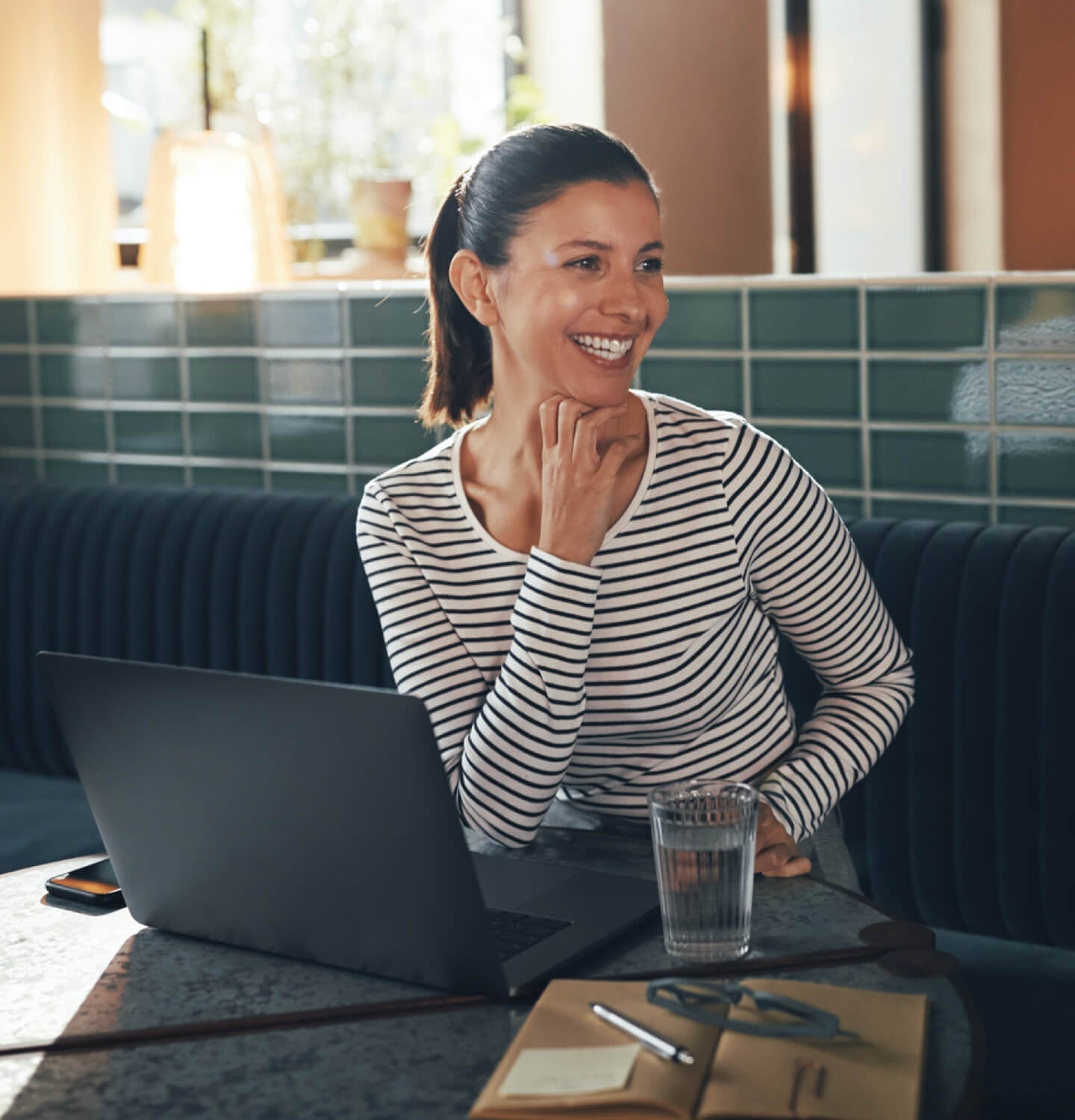 Dueño de una empresa sonriendo mientras bebe una taza de café y trabaja en su página web