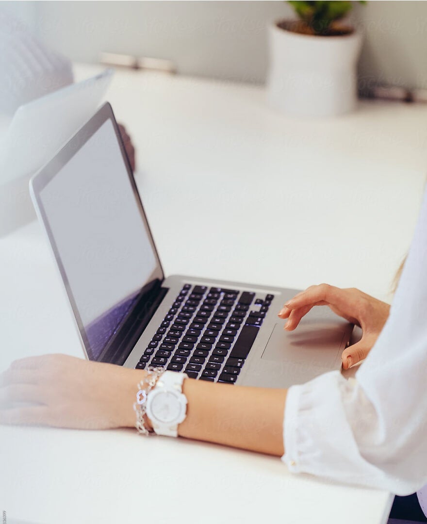 Ein lächelnder Unternehmer, der eine Tasse Kaffee in der Hand hält, während er an seiner Website arbeitet.