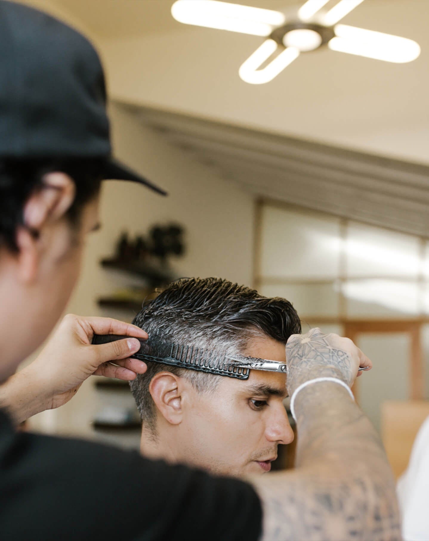 A barber works on a customer in a stylish salon